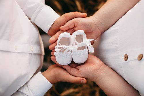 Baby shower a Milano: genitori con in mano scrapette di bambino