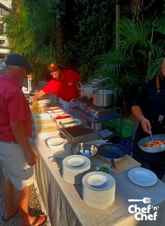 party in villa sul lago di como: cucina all'aerto con cuochi che danno la pasta fresca cucinata sul momento